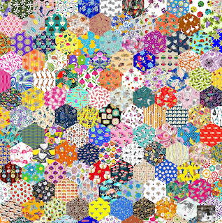 Dense hexagonal patchwork quilt with multicolored fabric patches in various patterns including florals and polka dots