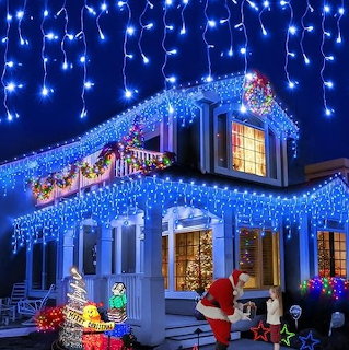 House covered in blue and white icicle Christmas lights with Santa figure and colorful holiday decorations