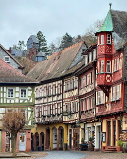 Row of colorful half-timbered houses in Miltenberg Bavaria with ornate wooden frameworks and red turet