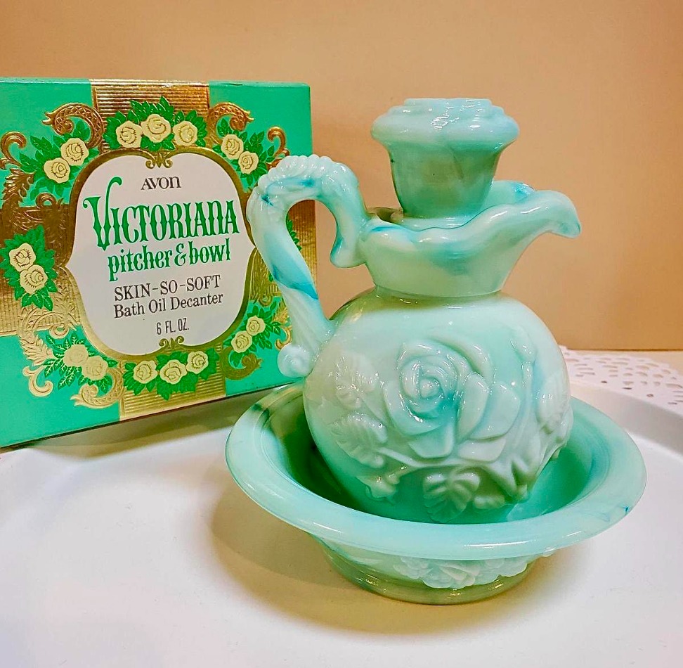 Turquoise vintage Avon bath oil bottle beside a decorative green Avon box
