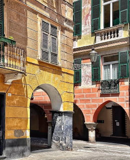 Colorful historic buildings with arched doorways and shuttered windows in Chiavari, Italy