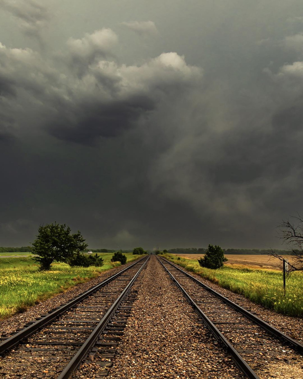 Dark storm clouds building over a wide open landscape under a dramatic sky.