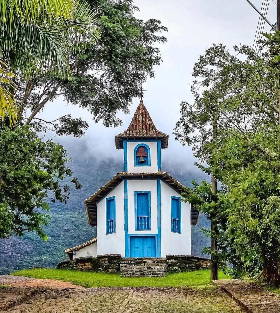 Small white roadside chapel with tiled roof and arched entrance