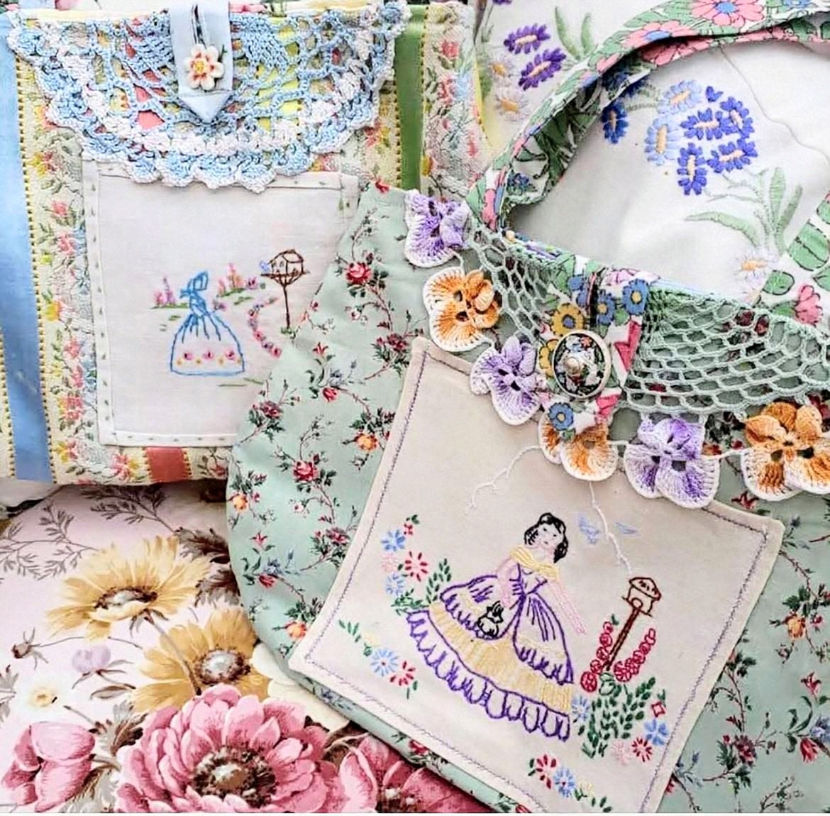 Vintage embroidered linens and handkerchiefs arranged with pink and yellow flowers on floral fabric