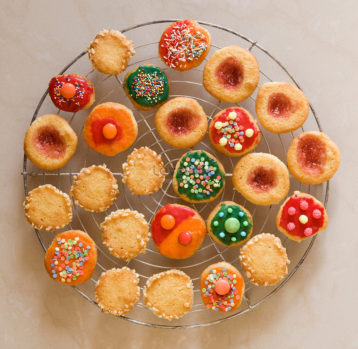 Overhead view of decorated Christmas cookies with colorful icing and sprinkles on a glass plate