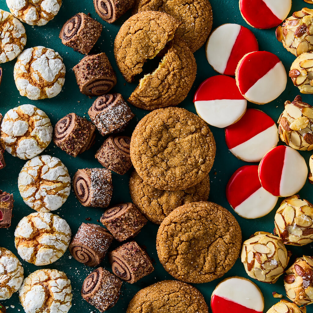 Variety of Christmas cookies and festive treats arranged on a teal surface