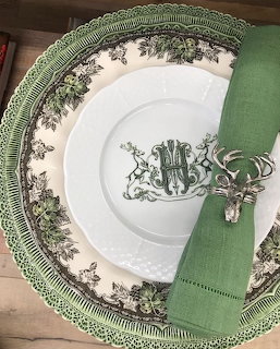 Green floral china dinner plate with white monogrammed plate, deer napkin ring, and green linen napkin