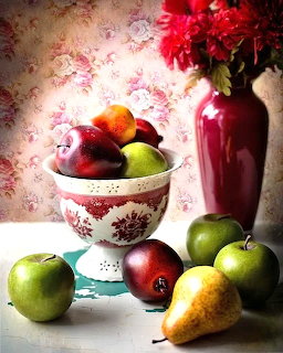 Painted still life with apples, pears, a floral bowl, and a red vase of flowers on a table