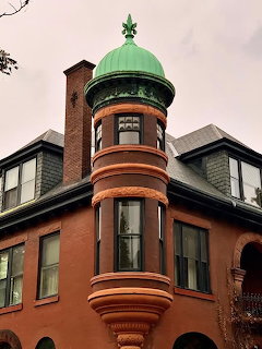 Victorian brick house with green copper dome turret and ornate architectural details