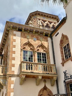 Ornate tower of Ca' d'Zan mansion with terracotta roof, arched windows, and decorative balcony