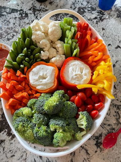 Overhead view of fresh vegetable platter with assorted raw vegetables arranged around two bowls of white dip