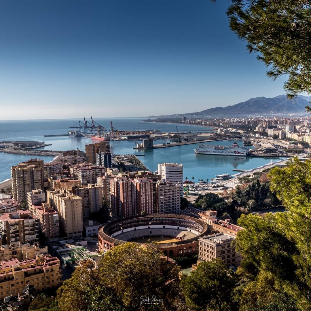 Aerial view of Málaga port, bullring, and coastal cityscape with mountains
