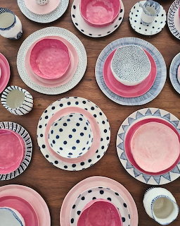 Assorted decorative ceramic plates with polka dots and geometric patterns on wood table