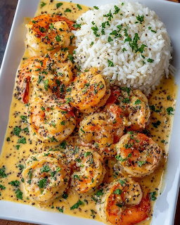 Plate of garlic butter shrimp with white rice and parsley garnish
