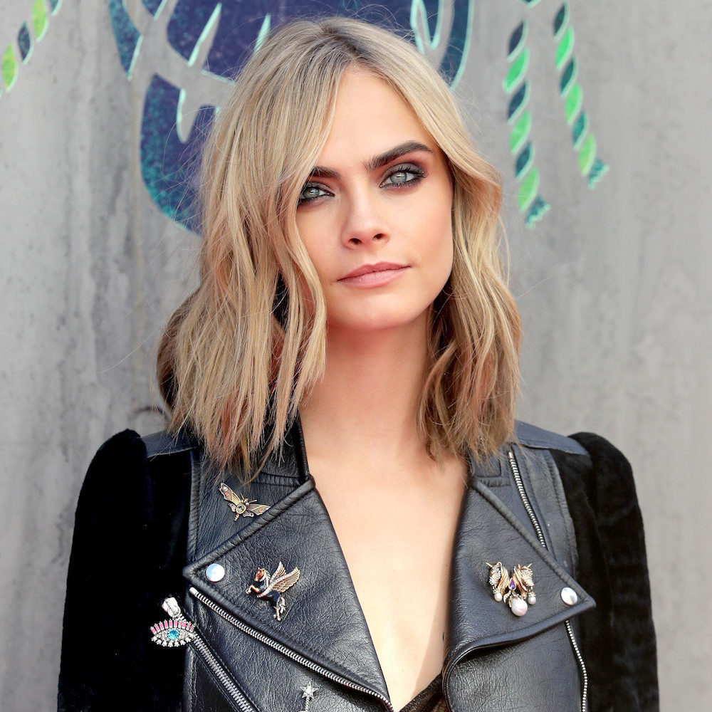 Portrait of blonde woman in black leather jacket with decorative pins