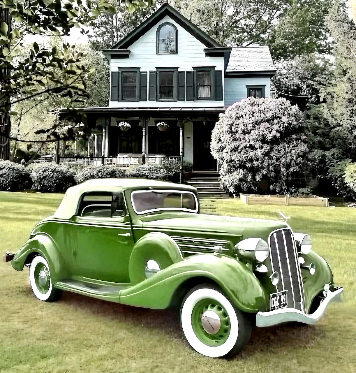 Green 1935 Hudson 8 convertible coupe parked in front of white Victorian house