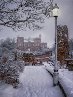Snowy path with a lamppost and the ruins of Scarborough Castle in the background