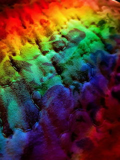 Colorful powder explosion with rainbow spectrum from red to purple creating swirling textured clouds