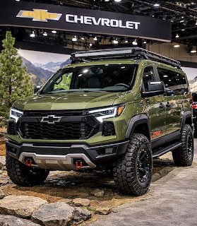 Green Chevrolet off-road SUV on rocky display at an indoor auto show