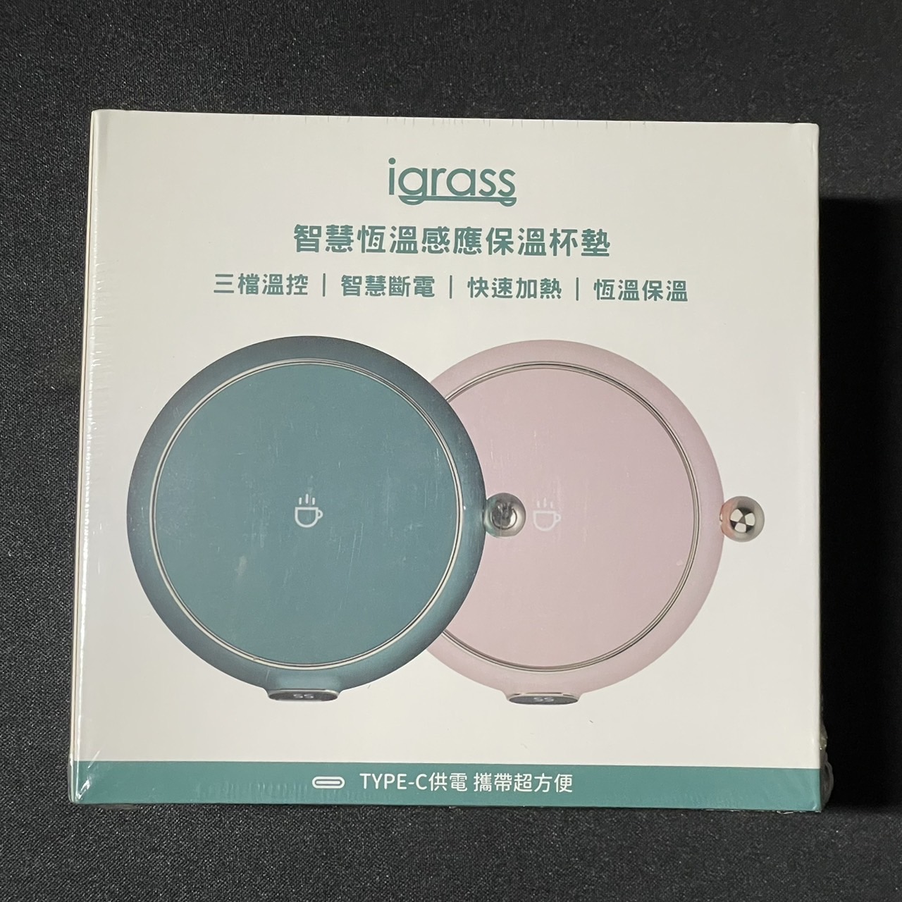 Square photo of warming coaster product packaging with two round devices on a white box