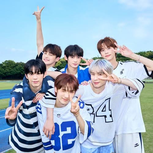 Six young men posing outdoors in sporty casual clothes, smiling and making peace signs