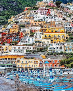 Colorful buildings cascading down hillside to beach in Positano, Italy