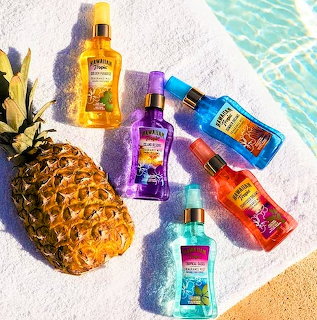 Hawaiian Tropic spray bottles on sand with pineapple and tropical leaf