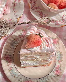 Slice of strawberry shortcake with whipped cream and a strawberry on a floral plate