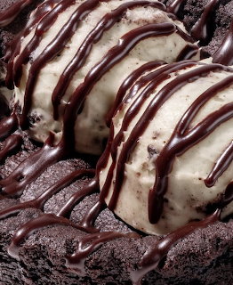 Vanilla ice cream with chocolate sauce drizzled on chocolate cake