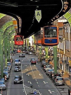 Suspension railway trains hanging above a city street in Wuppertal, Germany