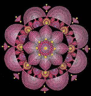 Symmetrical mandala with pink dotted circles and floral patterns on black background