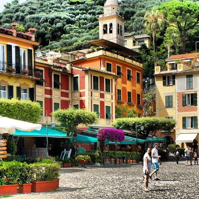 Colorful buildings and a church tower beside a cobblestone square in Portofino, Italy