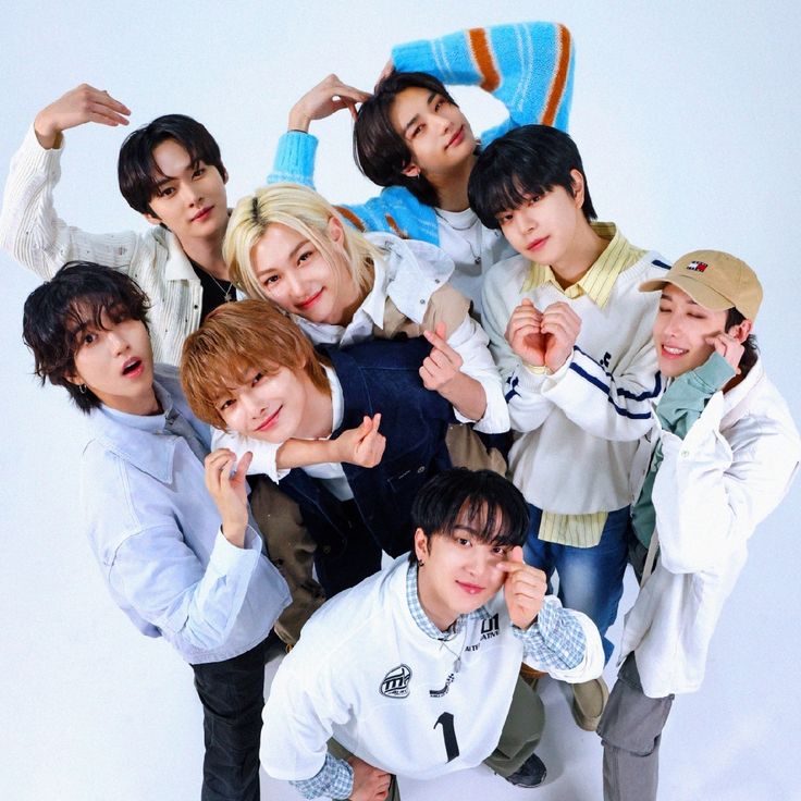 Eight Stray Kids members posing together in a bright studio portrait