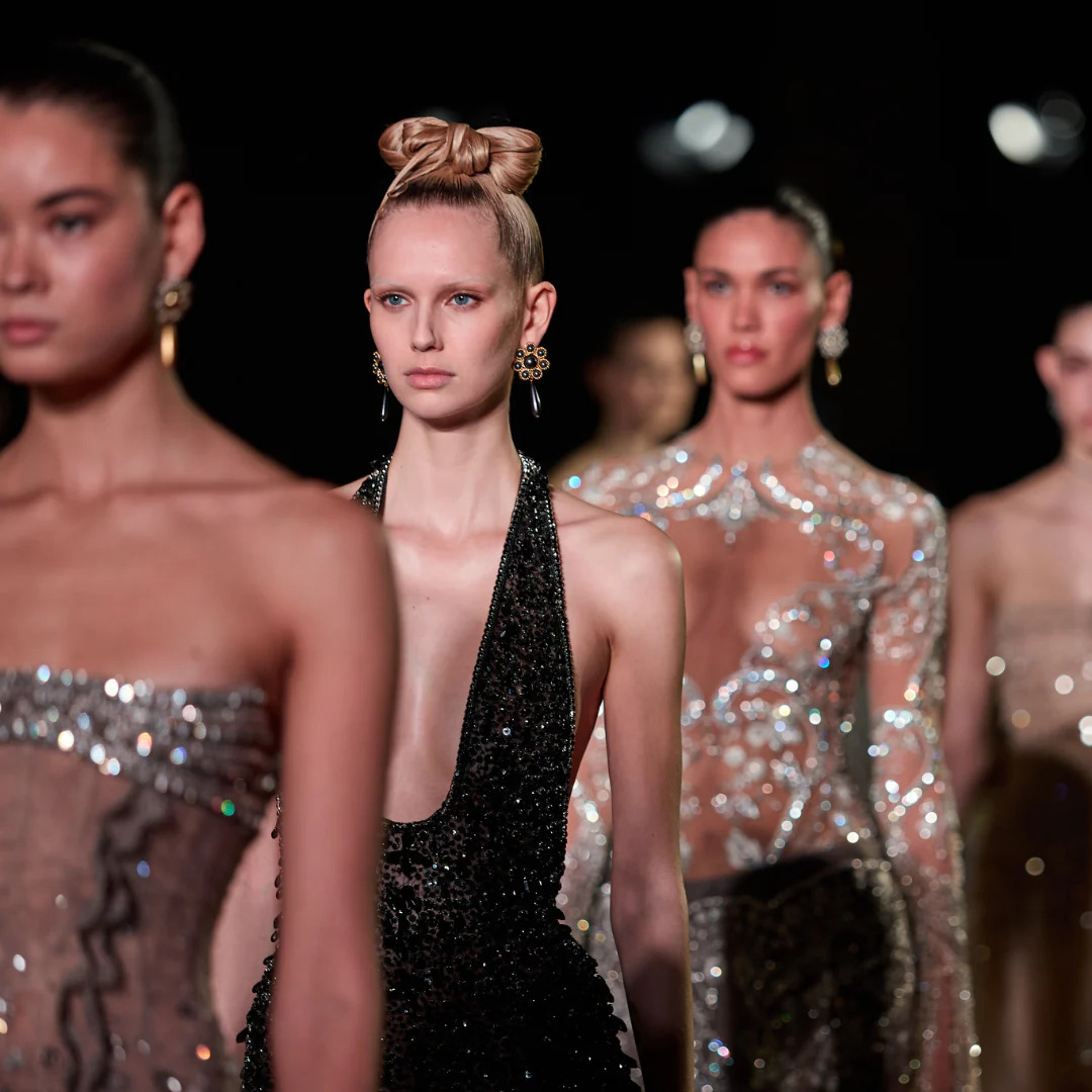 Fashion models walking on a runway in sparkling and sheer evening gowns