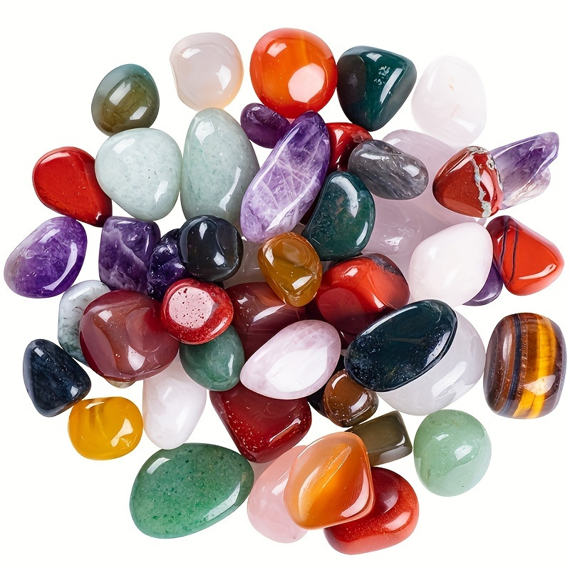 Colorful polished gemstones and crystals scattered on a white background