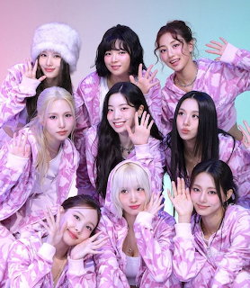 Nine young women in matching pink floral pajamas posing together in a group photo