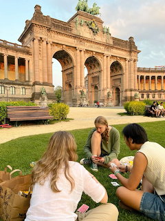 People relaxing on the grass before the Cinquantenaire Arch in Brussels, Belgium