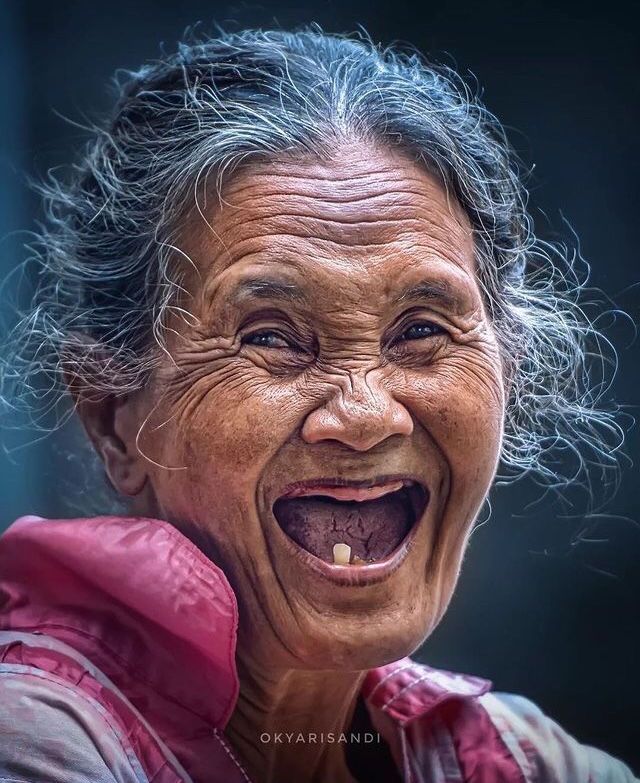 Close-up portrait of a laughing elderly woman with gray hair