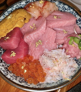 Close-up of a Japanese seafood bowl with assorted sashimi, sea urchin, salmon roe, and crab