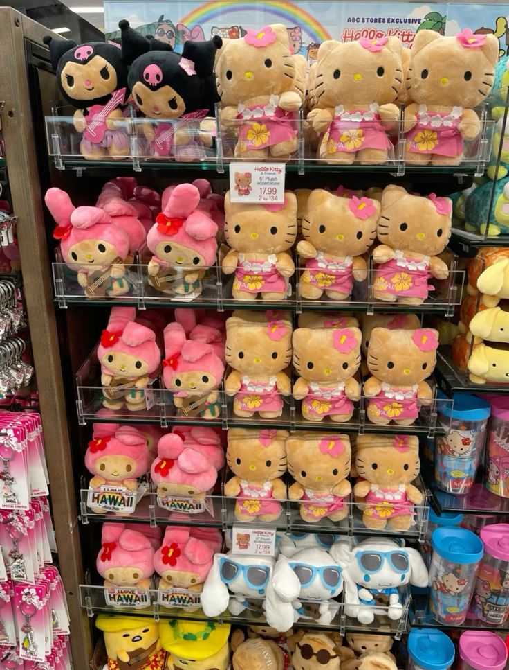Store shelf filled with Hello Kitty Sanrio plush toys in pink Hawaiian outfits and Kuromi figures