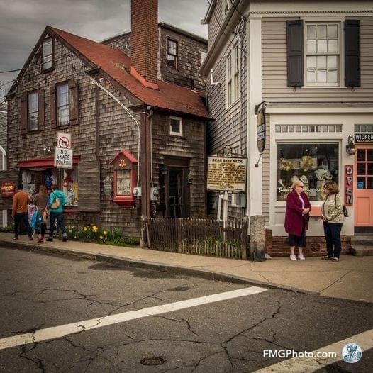 Historic street in Rockport with weathered buildings and pedestrians