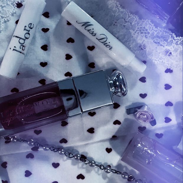Purple perfume bottles and cosmetics arranged in flatlay composition with hearts and lavender accents