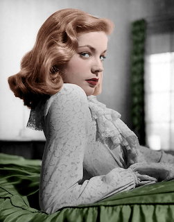 Colorized vintage photo of Lauren Bacall in a lace top looking over her shoulder with styled blonde hair