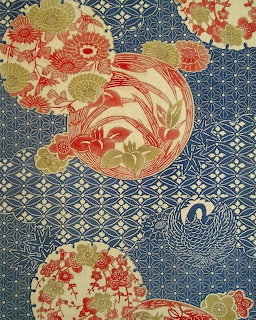 Traditional Japanese fabric pattern with circular medallions containing flowers and birds on blue geometric background