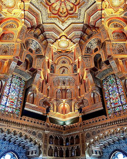 Elaborate ornate interior ceiling and arches of Cardiff Castle with golden decorations and stained glass windows