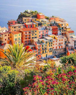 Colorful buildings of Cinque Terre village on a hillside above the blue Mediterranean Sea