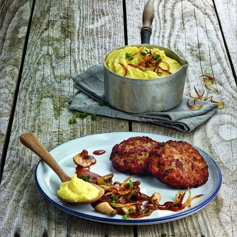 German frikadelle meatballs on plate with mustard and fried onions, bowl of potato soup with bacon on wooden table