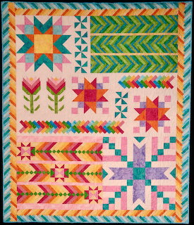 Colorful geometric patchwork quilt with stars, chevrons, and floral patterns in pink, teal, yellow, and green