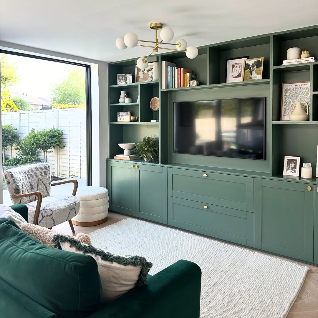 Living room with teal built-in bookcase, green sofa, and bright window view