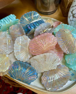 Pastel seashell hair claw clips with pearls and glitter on gold tray